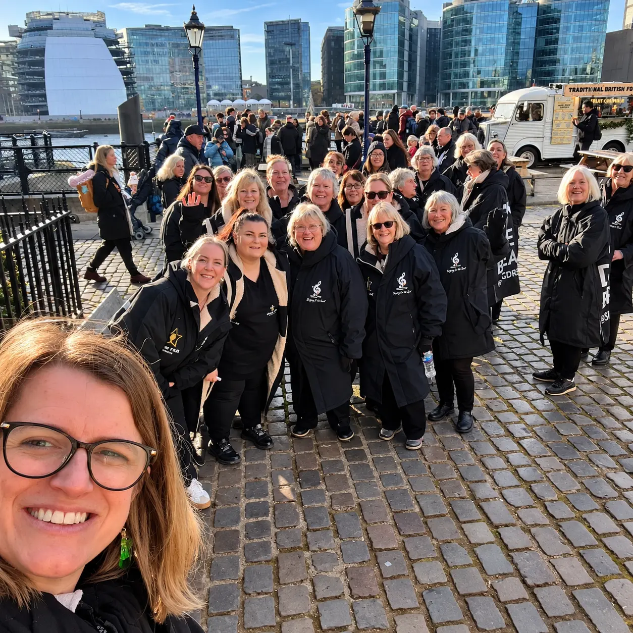 The choir sharing a group selfie beside a city quay