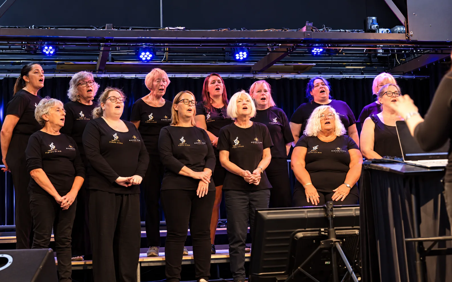 Singing for the Soul performing on stage under blue lights